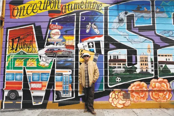  ?? Photos by Grace Li / The Chronicle ?? George CramptonGl­assanos next to a mural he assisted in painting in the Mission. He and his father also incorporat­ed mixed media into their art show.