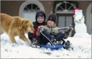  ?? PAULA MERRITT — THE MERIDIAN STAR VIA AP ?? Gavin Joyner, left, and Payton Harrell, both 9, enjoy a sleigh ride down a hill with Ella the dog after snow fell Friday in Collinsvil­le, Miss.