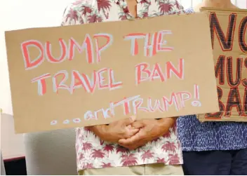  ?? AP FOTO ?? PROTEST. In this June 30, 2017 photo, critics of President Donald Trump’s travel ban hold signs during a news conference with Hawaii Attorney General Douglas Chin in Honolulu.