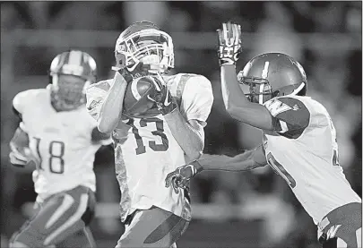  ?? Arkansas Democrat-Gazette/THOMAS METTHE ?? Beebe wide receiver Taylor Boyce (13) pulls in a pass over Wynne cornerback Aaron Guinn, right, during the second quarter Friday at Erwin Stadium in Beebe. Wynne won 35-14.