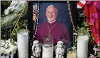  ?? PAUL BERSEBACH — ORANGE COUNTY REGISTER VIA SCNG ?? A photo of Auxiliary Bishop David O'Connell is surrounded by candles and flowers at his home in Hacienda Heights on Wednesday. One man has been charged in the bishop's murder.