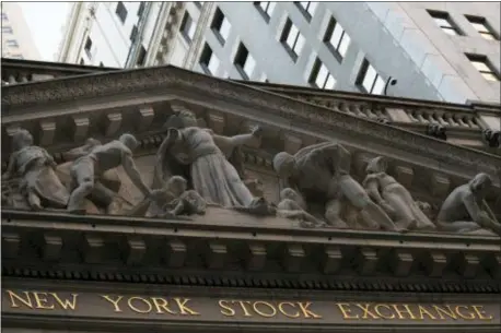  ?? MARY ALTAFFER — THE ASSOCIATED PRESS FILE ?? FILE- This file photo shows the New York Stock Exchange at sunset in lower Manhattan. On Monday stocks are opening slightly lower on Wall Street as the market gives back some of its gains from the week before.