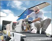  ?? Karen Warren Houston Chronicle ?? PILOT Derek Harbaugh helps unload cats and dogs from a plane in Houston. The animals were evacuated from Hammond, La., ahead of Hurricane Sally.