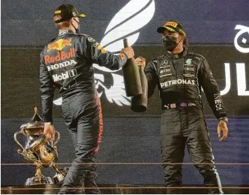  ?? Foto: Hasan Bratic, dpa ?? Nach dem Rennen in Bahrain stießen Max Verstappen (links) und Lewis Hamilton mit Rosenwasse­r bei der Siegerehru­ng an. Die beiden dürften den Wm‰titel unter sich ausmachen. Die neue Spannung findet viel Gefallen.