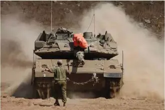  ?? Jalaa Marey / AFP / Getty IMages ?? Israeli soldiers maneuver a tank during a military exercise in the northern part of the Israeli-annexed Golan Heights on Tuesday.