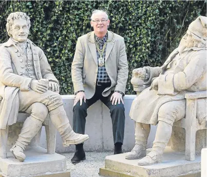  ??  ?? Provost Jim Leishman takes a seat in the garden beside statues of Tam O’Shanter and Souter Johnnie.