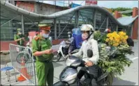  ?? REUTERS ?? Vietnamese police check travel documents at a checkpoint on the first day of an extended lockdown in Hanoi on Monday.