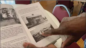  ?? ?? Ralph James points to an old photo of the Rosenwald School he has helped restore in St. George.