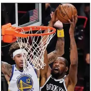  ?? (AP/Kathy Willens) ?? Brooklyn Nets forward Kevin Durant (right) puts up a shot while being guarded by Golden State Warriors forward Kelly Oubre during the Nets’ victory in the season opener Tuesday. Durant scored 22 points in his first game since rupturing his Achilles tendon while playing for the Warriors in the 2019 NBA Finals.