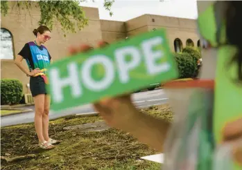  ?? DAVID GOLDMAN/AP ?? Allison Terracio, left, a Planned Parenthood advocacy programs manager, stands while Valerie Berry, program manager for the anti-abortion group A Moment of Hope, holds up a sign May 27 in Columbia, South Carolina.