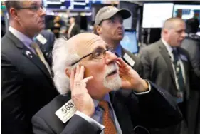  ?? AP PHOTO/RICHARD DREW ?? Trader Peter Tuchman works on the floor of the New York Stock Exchange on Thursday. The market’s recent decline was set off by a sharp drop in bond prices and a correspond­ing increase in yields last week and early this week.