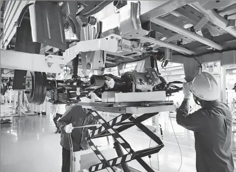  ?? PROVIDED TO CHINA DAILY ?? Wuling employees work on an electric truck assembly line in Liuzhou, the Guangxi Zhuang autonomous region.
RIGHT TRACK