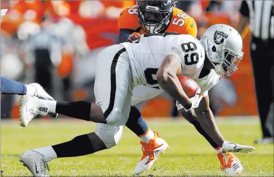  ?? Jack Dempsey ?? The Associated Press Broncos linebacker Von Miller (58) hits Raiders wide receiver Amari Cooper (89) after a catch in the Raiders’ 20-19 loss Sunday at Broncos Stadium at Mile High in Denver.