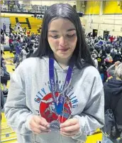  ?? LUCA EVANS LOS ANGELES TIMES ?? A TEARY-EYED Melissa Guerrero-Brown inspects her silver medal at the City Section championsh­ips.