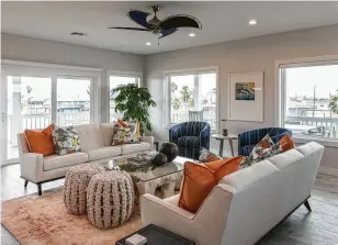  ??  ?? The living room features white sofas with blue and orange accents, all with a coastal feel. The home looks out on Copano Bay.