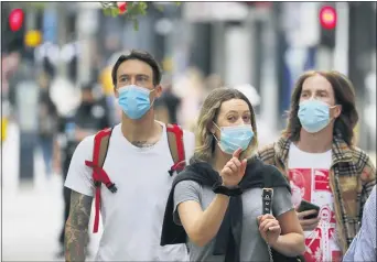  ?? FRANK AUGSTEIN — THE ASSOCIATED PRESS ?? Shoppers wearing protective face masks walk along Oxford Street in London, Tuesday, July 14, 2020