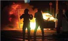  ?? ?? Unrest: A Garda car set on fire during the riots in Dublin city centre last week