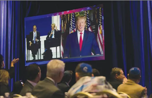  ?? PHOTOS BY MIKAYLA WHITMORE / THE NEW YORK TIMES ?? Former President Donald Trump, right, is joined by Matt Brooks, left, the executive director of the Republican Jewish Coalition, and former Sen. Norm Coleman, R-minn., as he addresses the Republican Jewish Coalition Nov. 19 in Las Vegas via a video feed. After Trump dined with performer Kanye West and with Nick Fuentes, an outspoken antisemite and Holocaust denier, even some of his staunchest supporters say they can no longer ignore the abetting of bigotry by the nominal leader of the Republican Party.