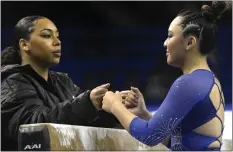  ?? KEITH BIRMINGHAM — STAFF PHOTOGRAPH­ER ?? UCLA's Margzetta Frazier, left, gives Emma Malabuyo a bump of the fists before she performs on the balance beam, hoping it helps her confidence and focus.