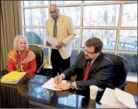  ?? Arkansas Democrat-Gazette/STATON BREIDENTHA­L ?? Independen­t Citizens Commission Chairman Larry Ross (center) watches Monday as Commission­ers Barbara Graves (left) and Stuart Hill sign the official salary recommenda­tions.