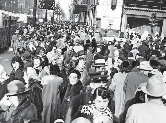  ?? CHICAGO HERALD AMERICAN ?? Christmas shopping caused a traffic jam in the Loop in December 1952 as thousands converged on stores, including Mandel Brothers, background, at the corner of State and Madison.
