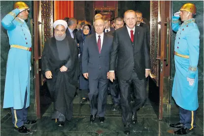  ??  ?? Präsidente­n-Triangel in Ankara: Hassan Rohani, Wladimir Putin und Gastgeber Tayyip Erdogan.