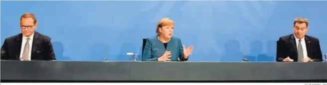  ?? FILIP SINGER / EFE ?? La canciller alemana, Angela Merkel, atiende ayer a los medios en Berlín flanqueada por el alcalde la capital, Michael Mueller, y el líder de Baviera, Markus Soeder.