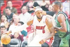  ??  ?? Miami Heat forward LeBron James drives against Boston Celtics guard Jeff Green (right), during the first quarter of a regular season NBA basketball game against the Boston Celtics in Miami on Friday, April 12, 2013. The Heat tied the franchise record...