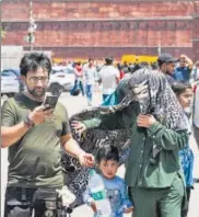  ?? ANI ?? A woman covers herself and her child with a cloth from the sun on a hot summer day, at Red Fort, in New Delhi on Wednesday.