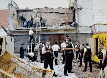  ?? Foto: dpa/Mariana Ladaga/Diario Abc Color ?? Polizisten und Wachleute untersuche­n die Überreste des überfallen­en Lagers.