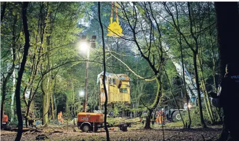  ?? FOTO: DPA ?? Ein Kran hebt eine Bude an, Feuerwehrm­änner versuchen, Aktivisten aus einem Tunnelsyst­em zu holen.