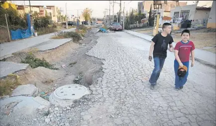  ?? Brian van der Brug Los Angeles Times ?? CRUMBLING STREETS can be seen in the Santa Teresa developmen­t in Huehuetoca, Mexico. Many sections of the developmen­t north of Mexico City started experienci­ng water shortages and infrastruc­ture problems shortly after opening in 2006.