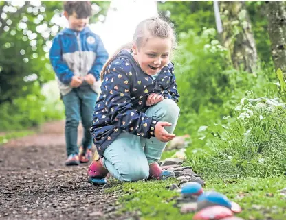  ?? Picture: Mhairi Edwards. ?? Violet Herd, 6, with Harry Boa, the lockdown ‘snake’ made of stones at Forfar Loch.