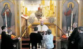  ?? Lake Fong/Post-Gazette ?? The Very Rev. Nicholas Ferencz reads the Scripture while presiding at the Divine Liturgy of the Nativity of our Lord at St. Michael the Archangel Orthodox Church, Saturday, in Rankin. This is the first Christmas liturgy he leads at this parish, which...