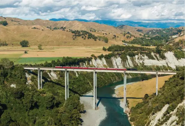  ?? ?? Et tog krydser en af New Zealands højeste broer over Rangitikei-floden. Foto: Getty Images