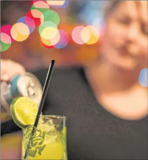  ?? CP PHOTO ?? Bar owner Rachel Conduit makes a drink in a glass containing a recycled straw in Toronto’s Farside bar. This holiday season, cocktail hour could really suck for the straw industry because some establishm­ents are ditching plastic straws as public...