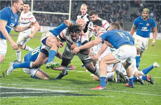  ??  ?? France’s Mathieu Bastareaud, centre, dives to score a try against Italy.