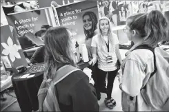  ?? Herald photo by Ian Martens ?? Bri Thomas, outreach connection­s lead with Youth One, speaks with students Darcie Weir and Megan Hanna during the University of Lethbridge Volunteer Fair Wednesday at the 1st Choice Savings Centre. @IMartensHe­rald