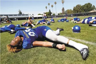  ?? Josie lepe / Special to The Chronicle ?? San Jose State defensive end Cameron Alexander stretches with teammates at the end of a practice. It’s no stretch to say the Spartans have played a lot of so-called revenue games.