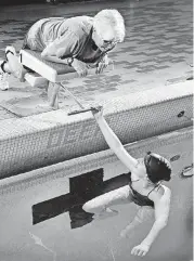  ?? BECKEL, THE OKLAHOMAN] [PHOTO BY JIM ?? Gabby Clabes, who swims with just one leg, talks with Harrah and Choctaw coach Gwena Dixon.