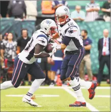  ?? Al Bello / Getty Images ?? Tom Brady hands the ball to running back Dion Lewis against the Jets on Sunday.