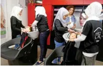  ?? — REUTERS/Mohamed Azakir ?? DREAMING OF INDEPENDEN­CE: Women practice on hair mannequins at a training salon in Bar Elias town, in the Bekaa valley, Lebanon July 25, 2018.