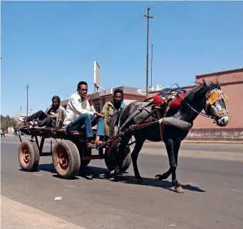  ?? ?? Local people ride a wagon on a street in Asmara, Eritrea