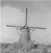  ?? Michael Ciaglo / Houston Chronicle ?? A rainbow appears over one of the windmills at Kinderdijk. The windmills pump water out of the area that sits below sea level.