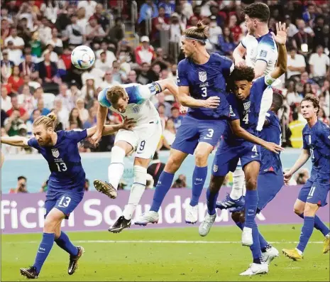  ?? Luca Bruno / Associated Press ?? England’s Harry Kane, center, tries to head the ball during a World Cup group B soccer match against the United States at the Al Bayt Stadium in Al Khor, Qatar, on Friday.