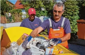  ??  ?? Ömer Pürlü (rechts) und Robert Pajonk sichten, ob sich im Gelben Container das Richtige befindet. Andernfall­s gibt es einen Aufkleber, der Müll wird nicht mitgenomme­n.