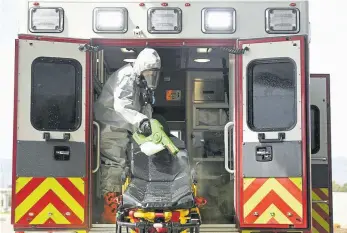  ??  ?? South Metro Fire Rescue Capt. Sheryl West uses an electrosta­tic sprayer to disinfect Medic 12 on April 19 in Littleton. Since the onset of the pandemic, South Metro Fire Rescue has created three “Decon” units to disinfect ambulances that have transporte­d patients with COVID-19 or suspected COVID-19.