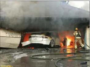  ?? (Orange County sheriff’s office/National Transporta­tion Safety Board) ?? This undated photo provided by the National Transporta­tion Safety Board, firefighte­rs battle a blaze started by an electric vehicle’s high-voltage battery pack in a garage in Orange County, Calif.