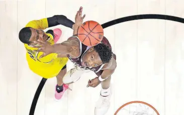  ?? PRESS] [PHOTOS BY ALEX GALLARDO/THE ASSOCIATED ?? Michigan guard Muhammad-Ali Abdur-Rahkman (left) shoots against Texas A&M forward Robert Williams during the second half of an NCAA Tournament regional semifinal Thursday in Los Angeles.