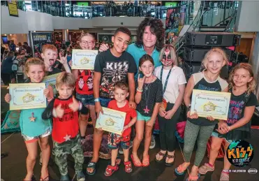  ?? Courtesy photo ?? (Above) KISS lead guitarist Tommy Thayer, center, smiles with children who hold up copies of the children’s book “Ernest Hummingbir­d” on the KISS Kruise in 2018. (Below) Animator and author David Feiss, who created the animated show, “Cow and Chicken,”...
